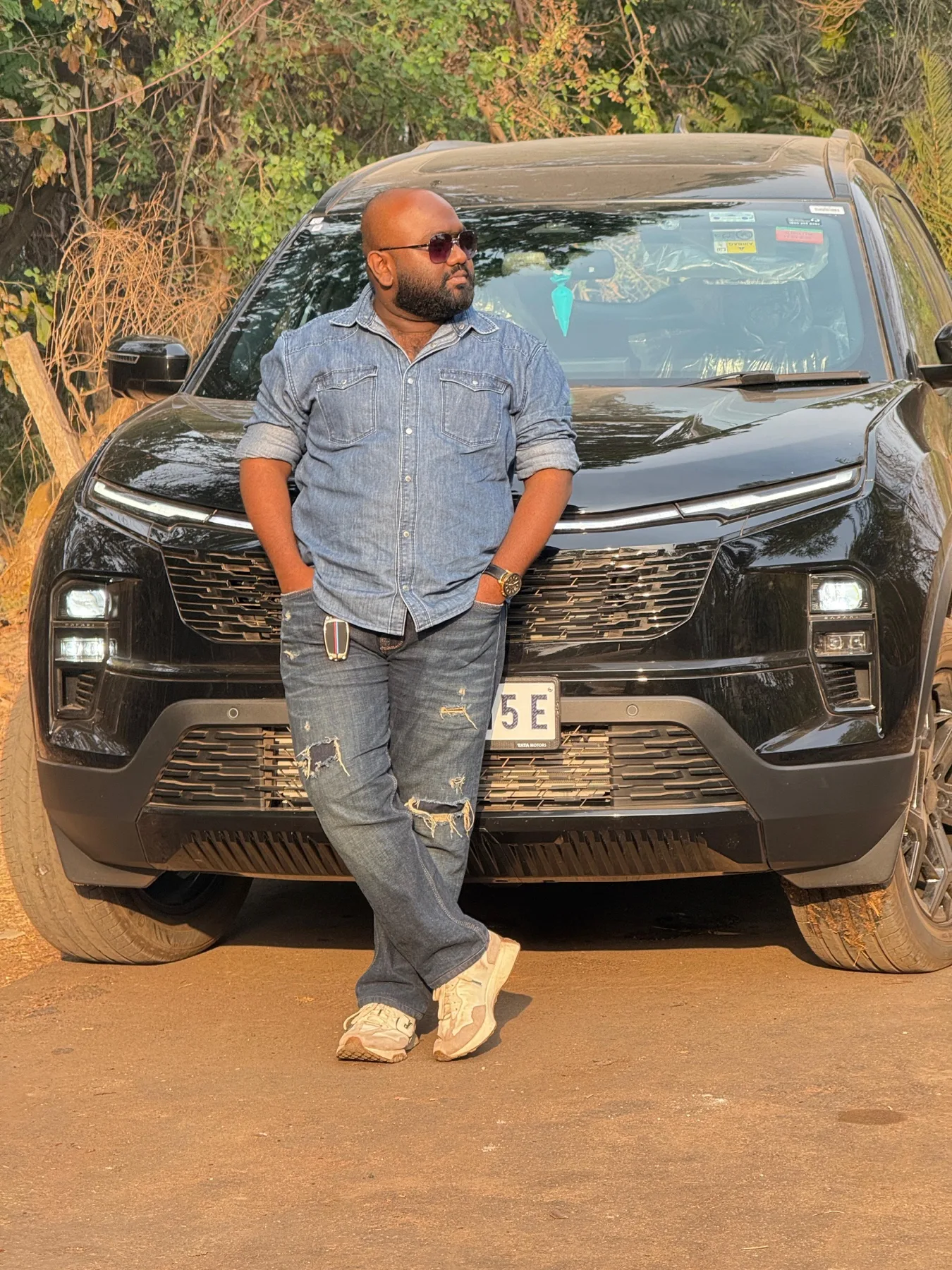 Standing beside a car on a dirt road